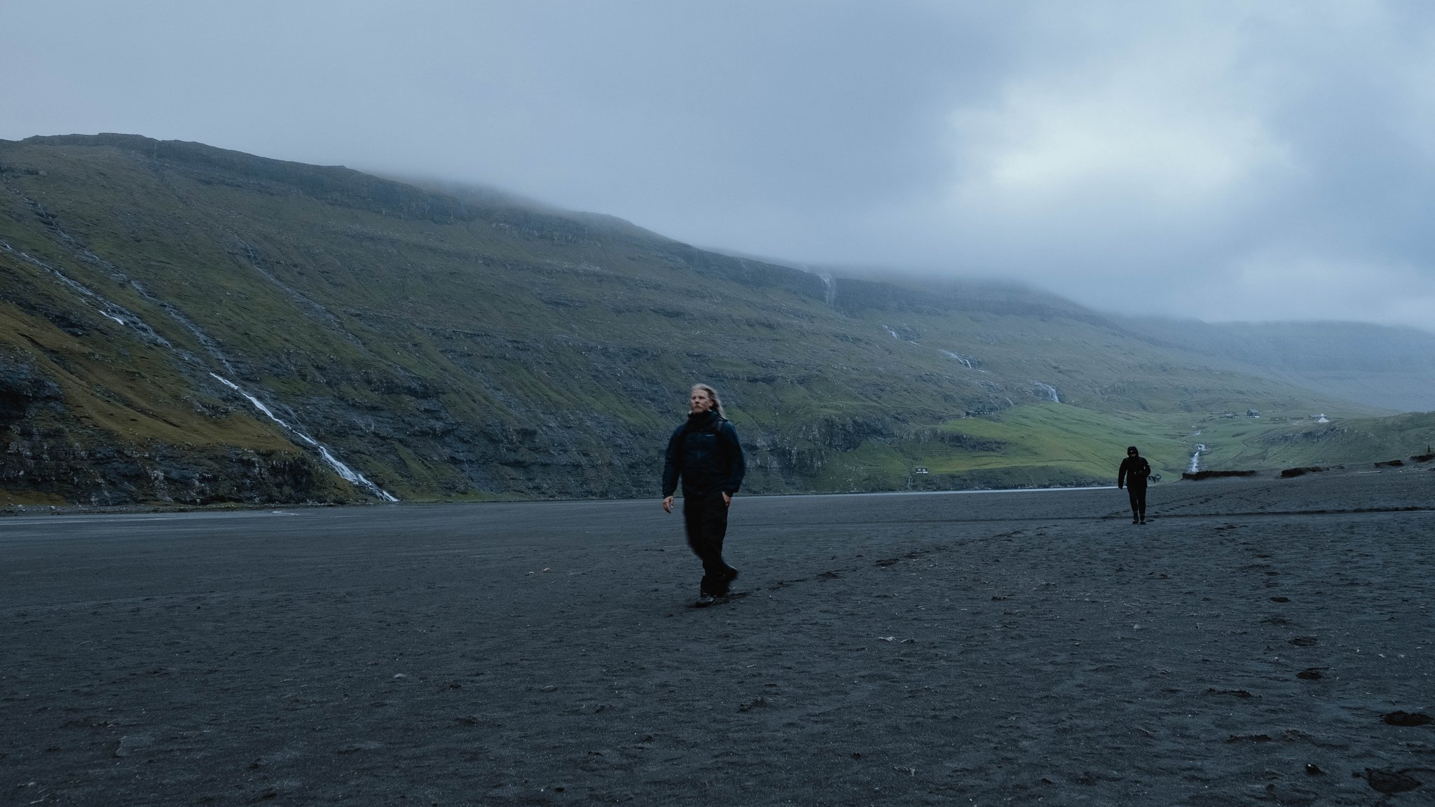Two figures crossing a remote landscape, photographed by Odin Oddekalv